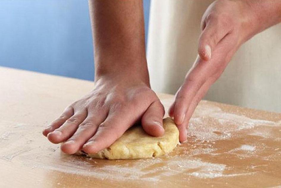 Flattening pastry on lightly floured surface.