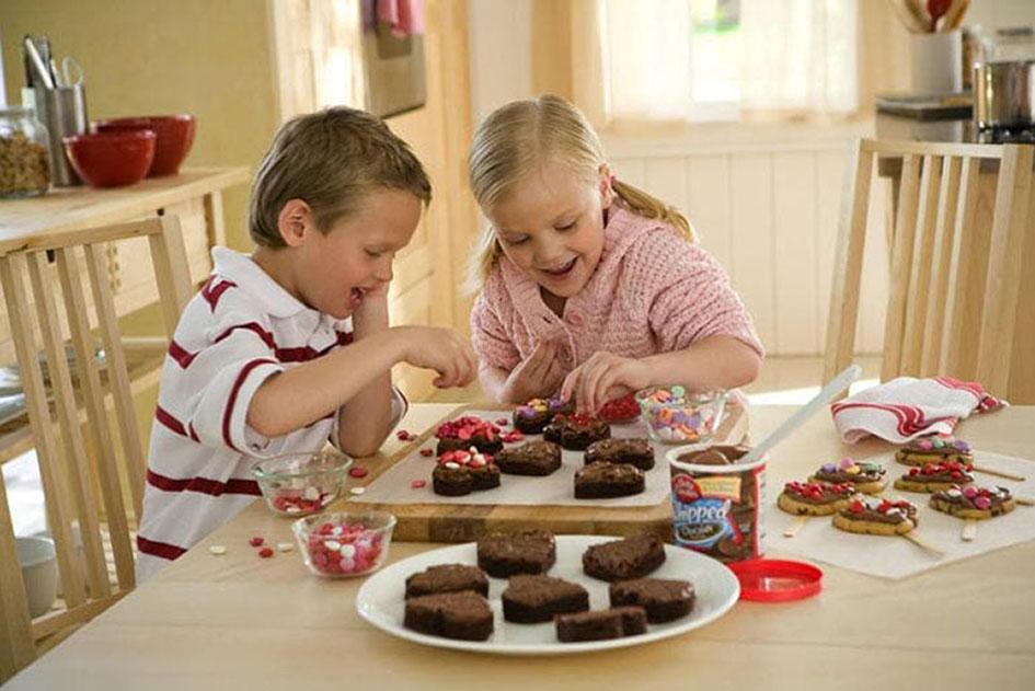 Baking with Kids - Two children happily making chocolate brownies in the kitchen, using child-friendly baking equipment and utensils