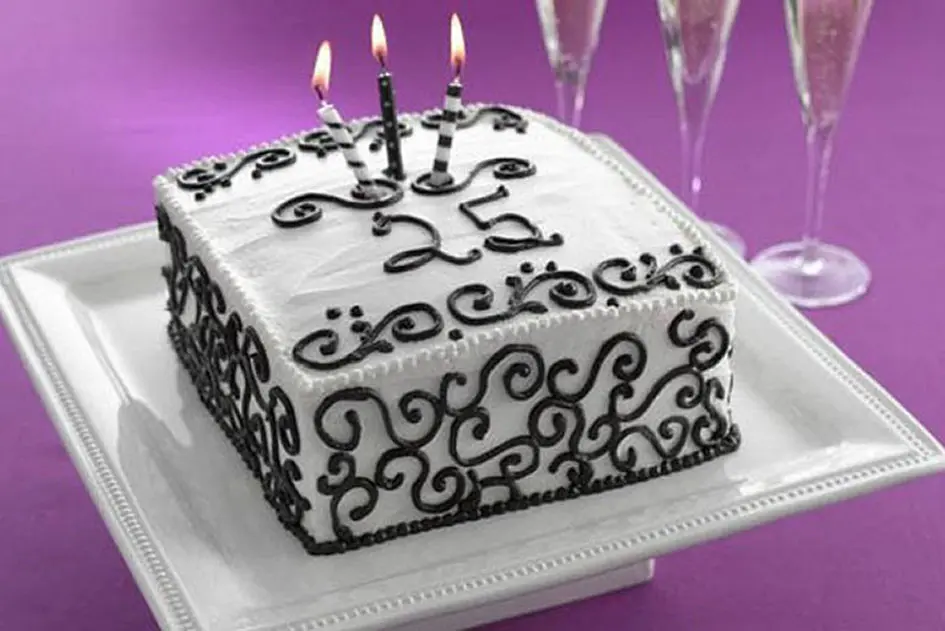 Decorated white cake with 3 candles on it
