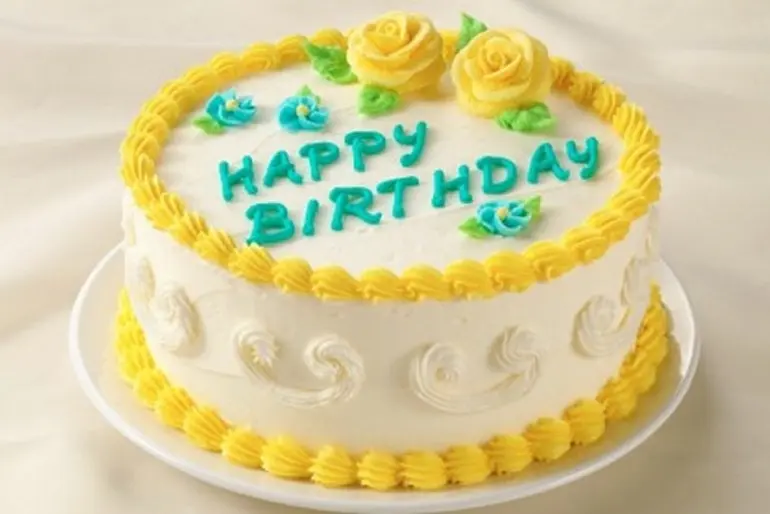 Birthday cake with white, yellow, and blue green frosting