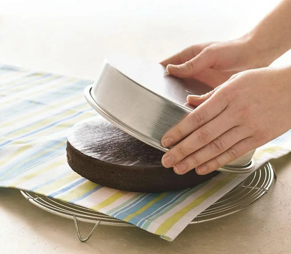 Tips for Making Cakes - Towel-covered rack placed on cake layer, flipped upside down to remove pan