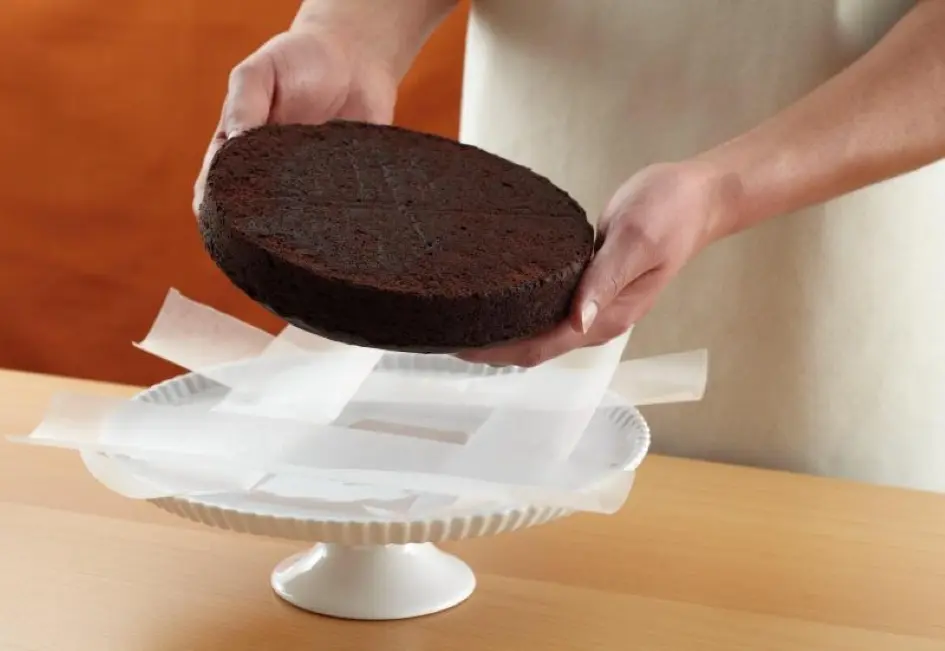 Waxed paper strips placed around cake plate edge protect it while frosting; easily removable later