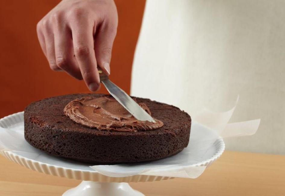 Tips for Making Cakes - A layer cake with creamy or fluffy frosting spread on top, leaving a small border around the edge
