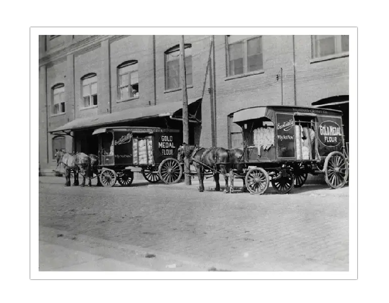 Two horse pulled delivery vehicles in leaving the mill.
