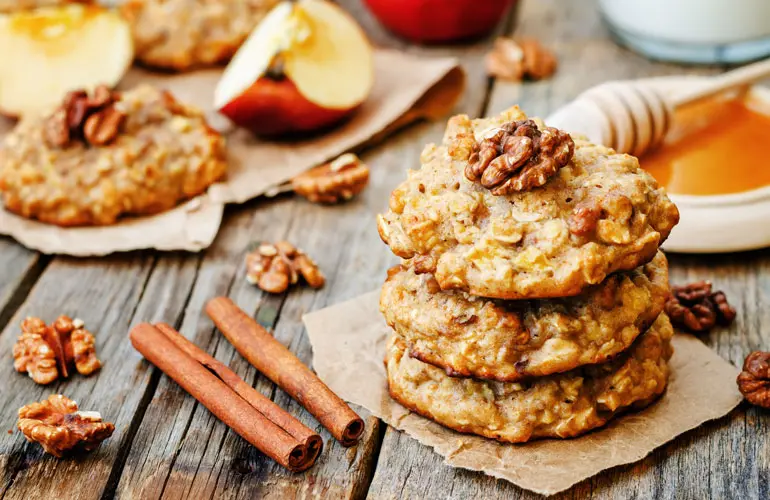 Close-up of some baked oatmeal and nut cookies on a wood outdoor table.